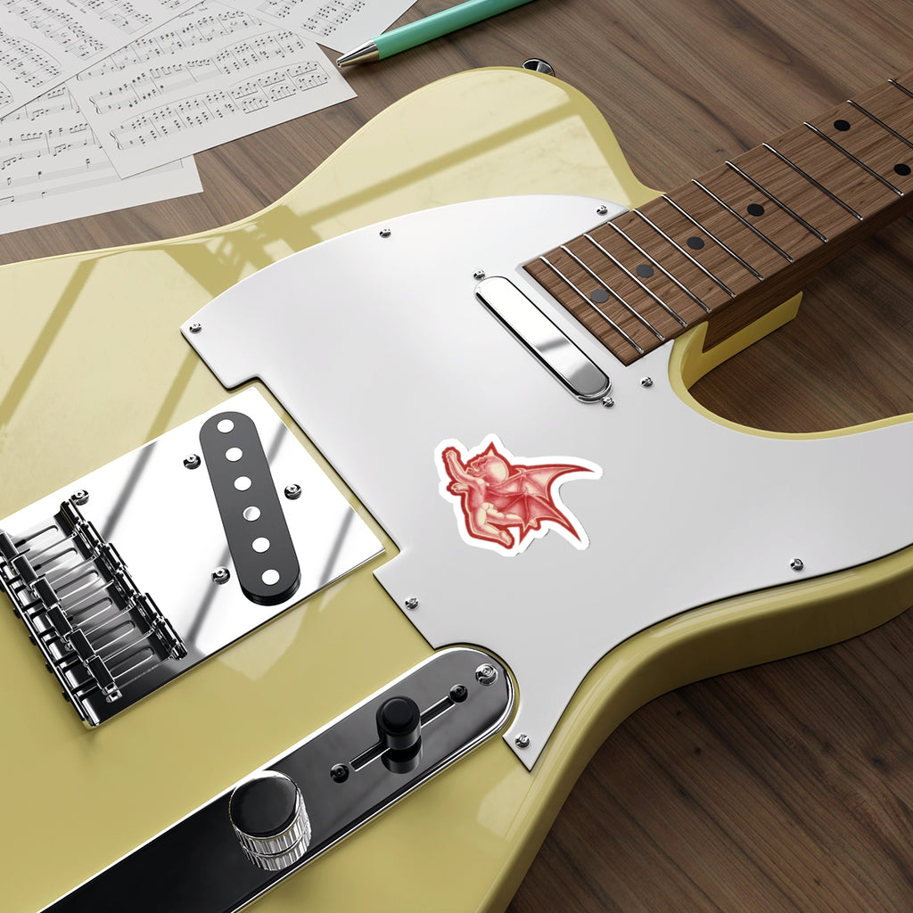 A mock up of my original design Aourim © as a sticker in Red monochrome with a white boarder of a winged creature with a skull on a white background on a mock up green electric guitar